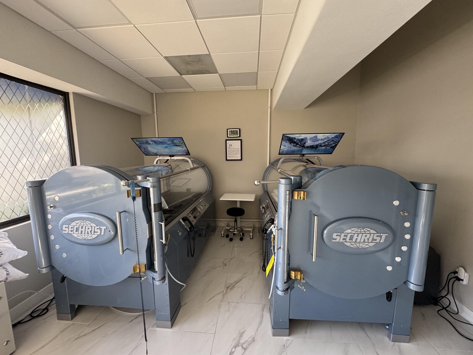 Two Sechrist monoplace hyperbaric chambers side by side in one of our treatment rooms